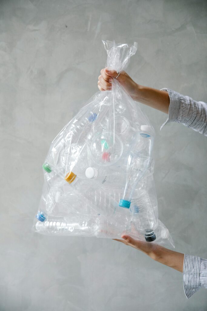 a person holding a plastic bag full of bottles